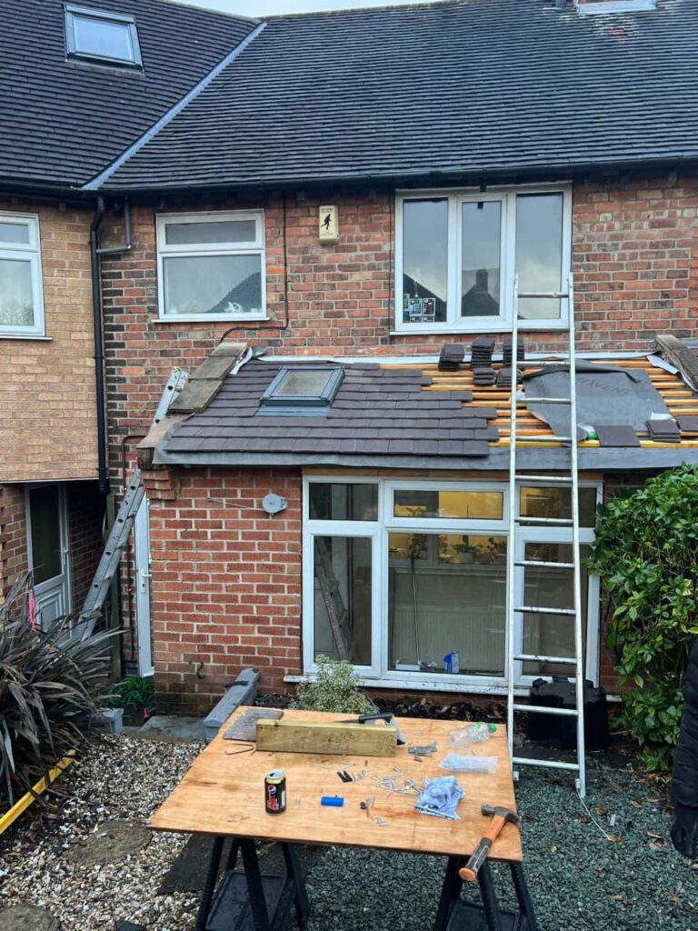 This is a photo of a roof extension that is having new roof tiles installed. This is a photo taken from the roof ridge looking down a tiled pitched roof on to a flat roof. Works carried out by Sidcup Roofing Repairs